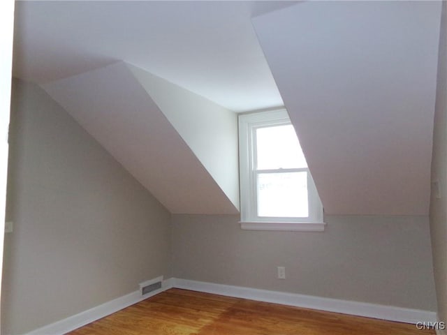 additional living space with lofted ceiling and light wood-type flooring