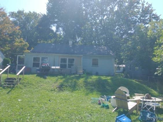 rear view of property with a lawn