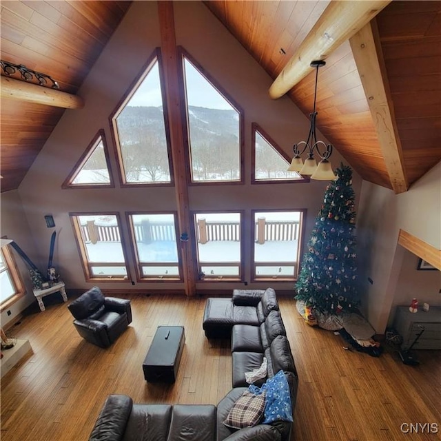 living room featuring beamed ceiling, an inviting chandelier, and plenty of natural light