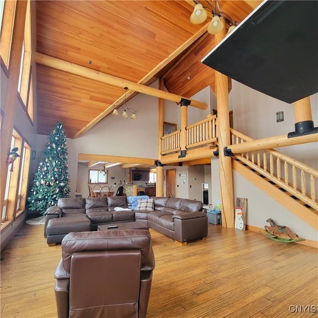 living room with light hardwood / wood-style floors, high vaulted ceiling, and wooden ceiling