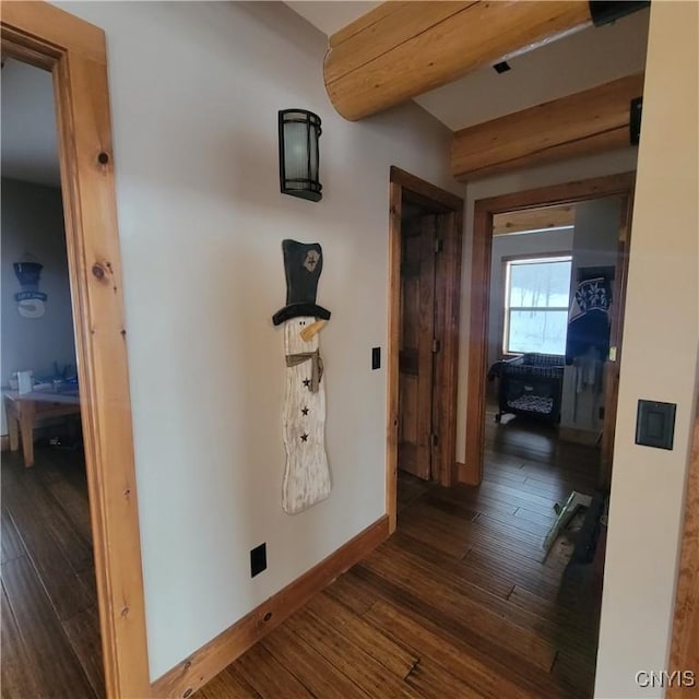 corridor featuring beam ceiling and dark wood-type flooring