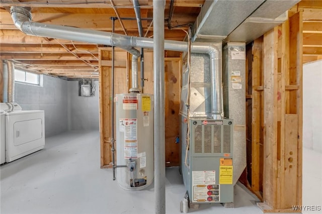 utility room featuring washing machine and dryer, water heater, and heating unit