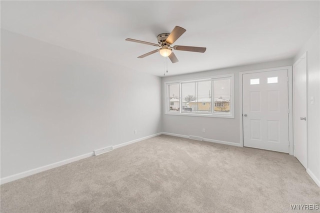 empty room featuring ceiling fan and light colored carpet