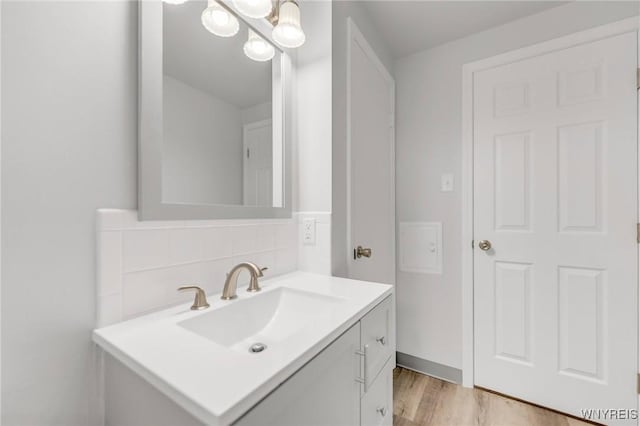 bathroom with backsplash, hardwood / wood-style floors, and vanity