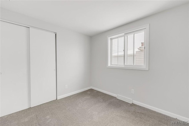 unfurnished bedroom featuring carpet flooring and a closet