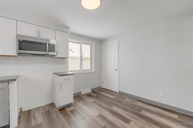 kitchen with white cabinetry and light hardwood / wood-style flooring