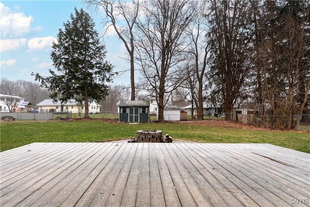 wooden terrace featuring a yard, a shed, and an outdoor fire pit