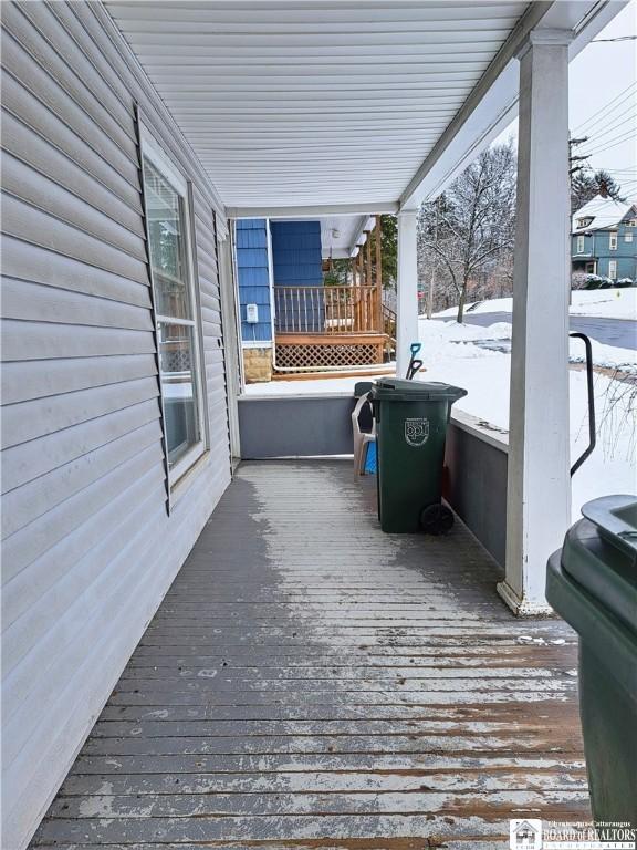 snow covered deck with covered porch