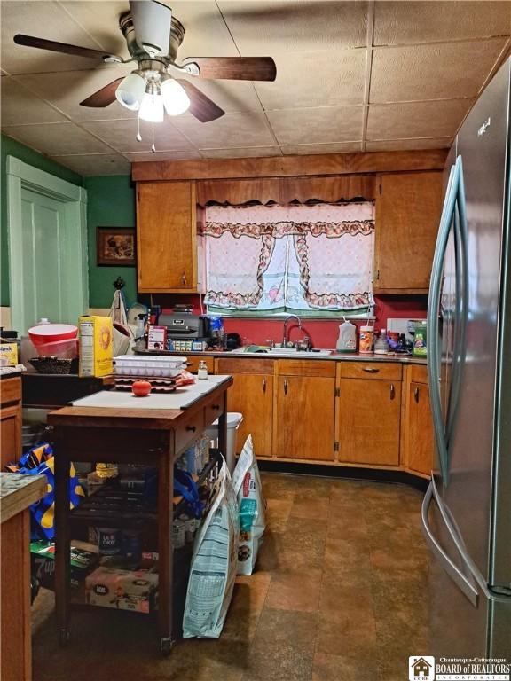 kitchen with stainless steel fridge, sink, and ceiling fan