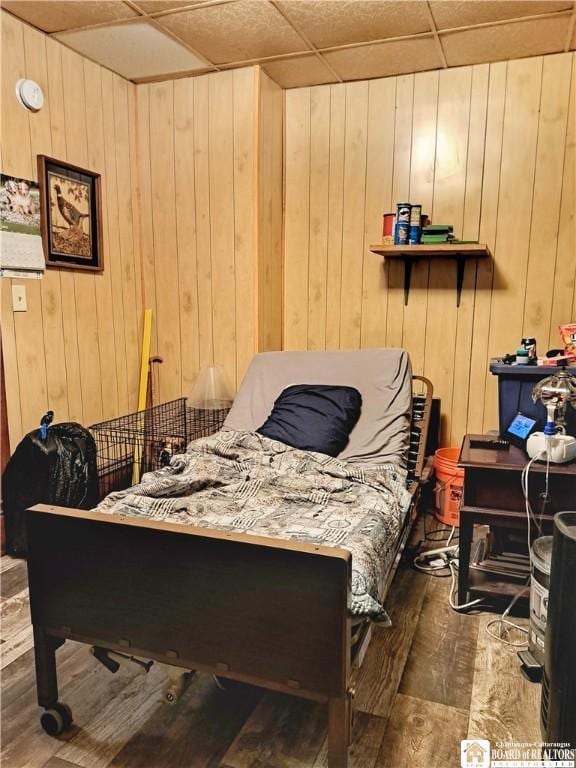 bedroom featuring dark wood-type flooring and wood walls