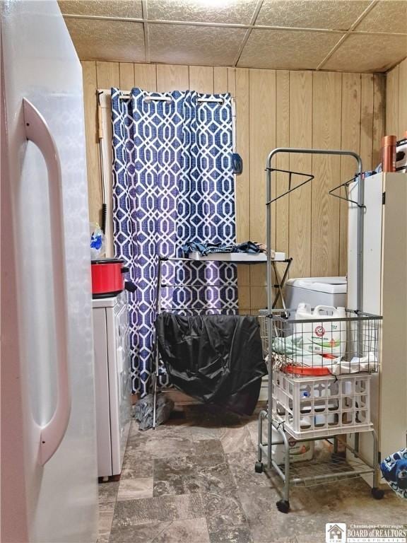 miscellaneous room with washer / clothes dryer, wood walls, and a drop ceiling