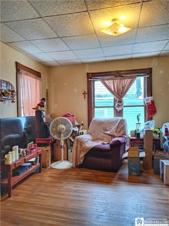 living room featuring a paneled ceiling and hardwood / wood-style floors