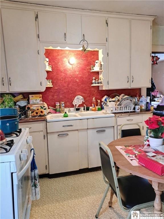 kitchen featuring white cabinets and white range oven