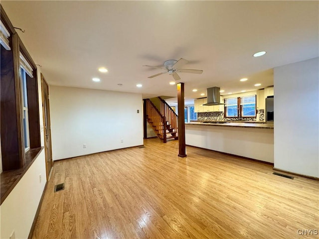 unfurnished living room featuring light wood-type flooring and ceiling fan