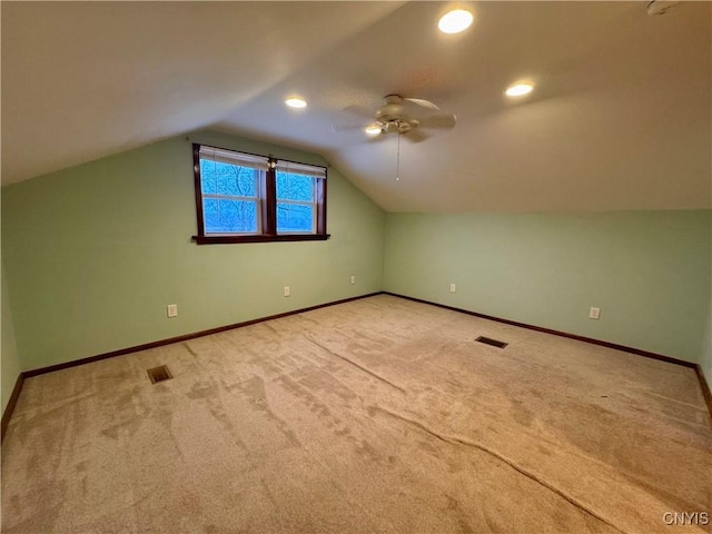 additional living space with ceiling fan, light colored carpet, and vaulted ceiling