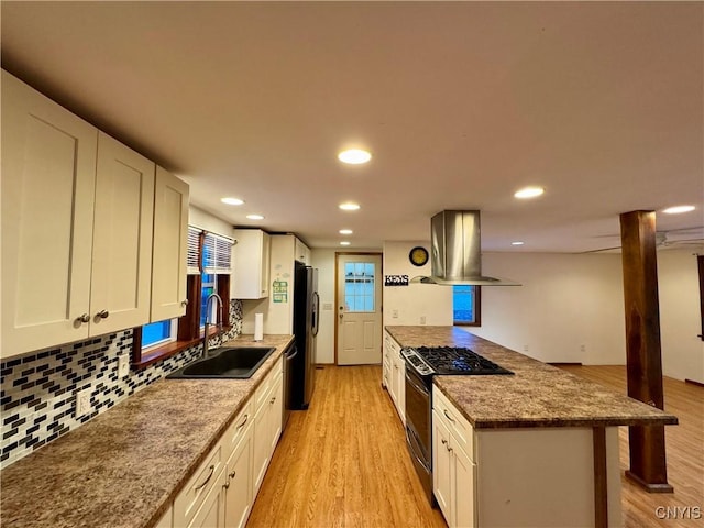 kitchen with sink, appliances with stainless steel finishes, light hardwood / wood-style floors, white cabinetry, and island exhaust hood