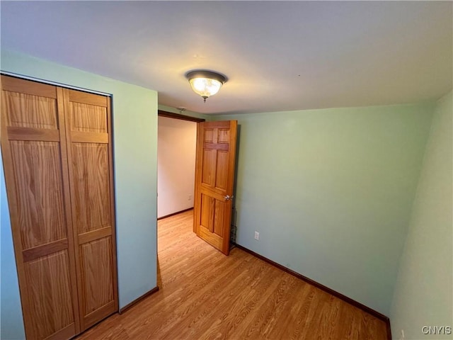 unfurnished bedroom with light hardwood / wood-style flooring and a closet