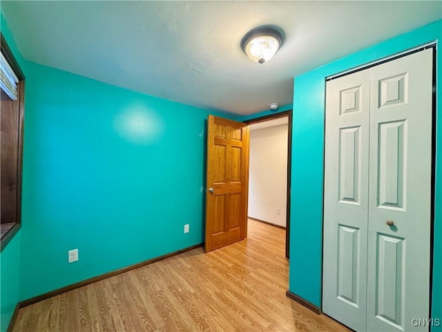 unfurnished bedroom with a closet and light hardwood / wood-style floors