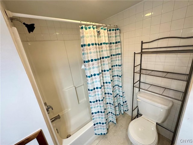 bathroom with tile patterned floors, toilet, tile walls, and shower / tub combo