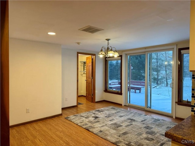 interior space with light hardwood / wood-style floors and an inviting chandelier