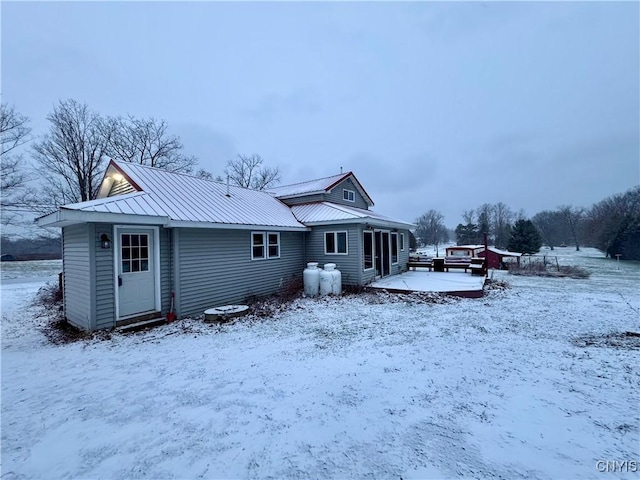 view of snow covered back of property