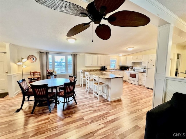 dining space featuring crown molding, light hardwood / wood-style flooring, ceiling fan, and sink