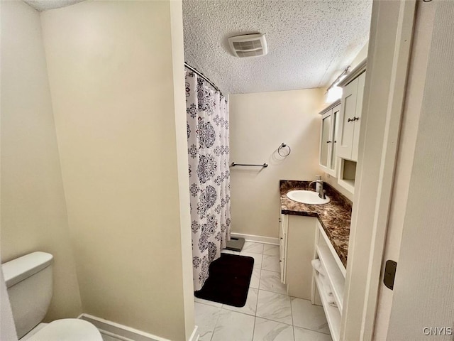 bathroom featuring vanity, toilet, a textured ceiling, and walk in shower