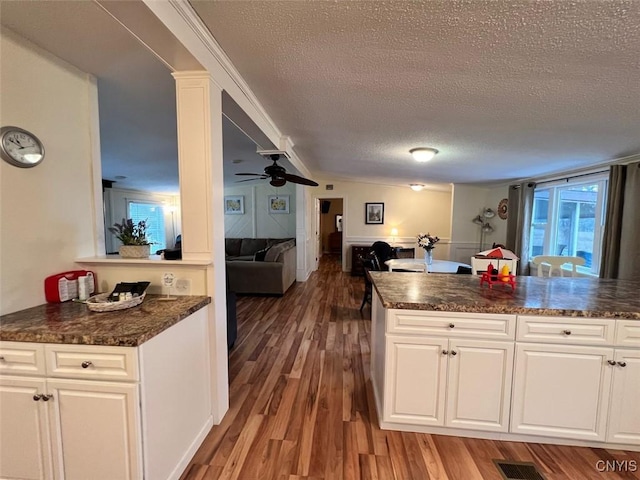 kitchen featuring kitchen peninsula, white cabinetry, and a textured ceiling