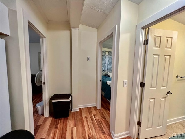 corridor featuring light hardwood / wood-style floors and a textured ceiling