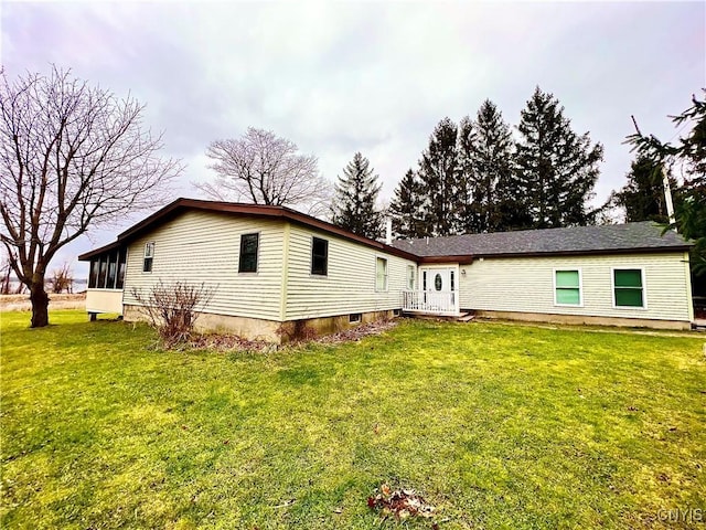 back of property featuring a sunroom and a yard