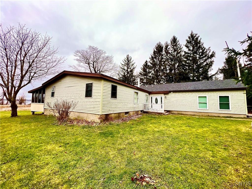21357 Storrs Rd, Hounsfield, NY 13685 - back of property featuring a sunroom and a yard