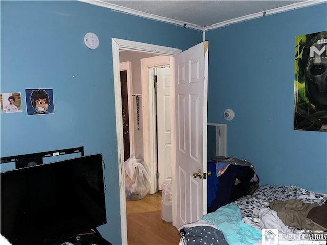 bedroom featuring wood-type flooring and ornamental molding