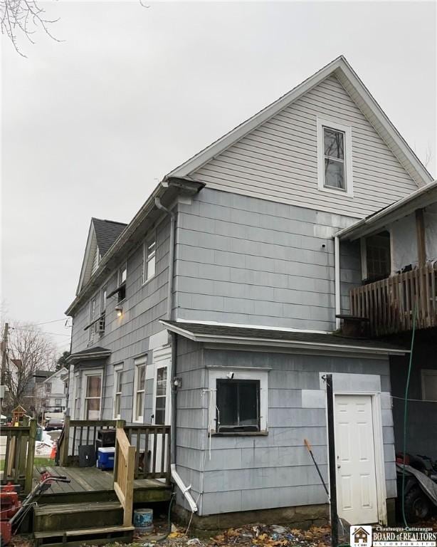 view of property exterior featuring a wooden deck and a balcony