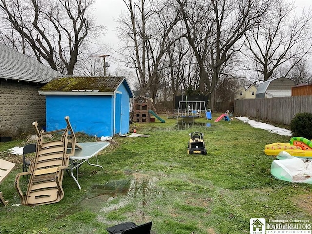 view of yard featuring a trampoline, a shed, and a playground