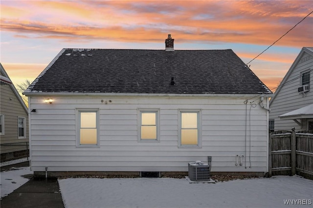 back house at dusk featuring central AC unit