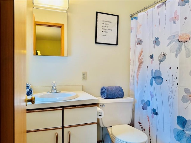 bathroom featuring a shower with shower curtain, vanity, and toilet