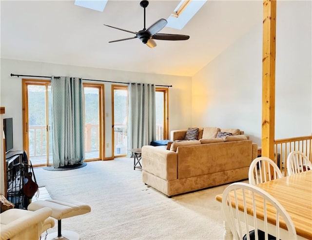 carpeted living room featuring ceiling fan and lofted ceiling with skylight