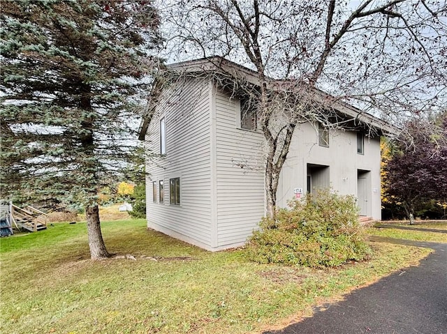 view of property exterior featuring a garage and a lawn