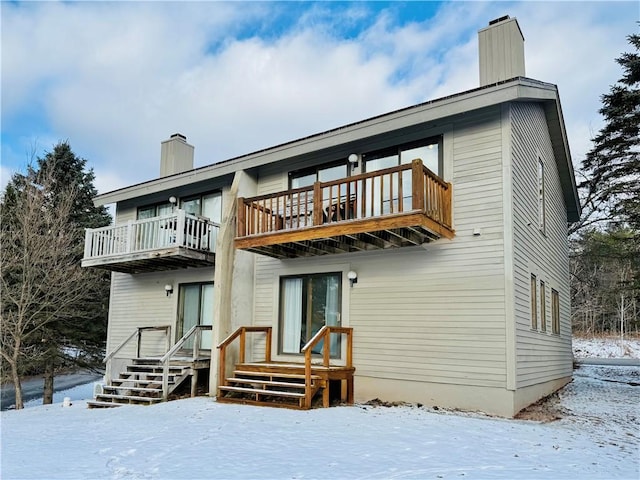 snow covered property featuring a balcony