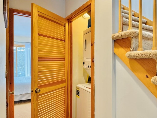 clothes washing area with carpet floors and stacked washer and clothes dryer