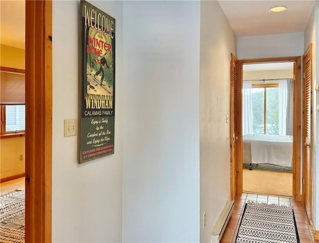 corridor featuring light tile patterned floors and baseboard heating