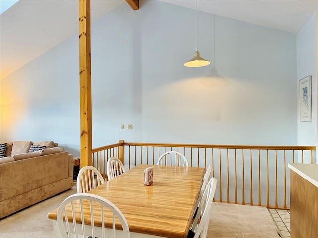 carpeted dining area with vaulted ceiling with beams