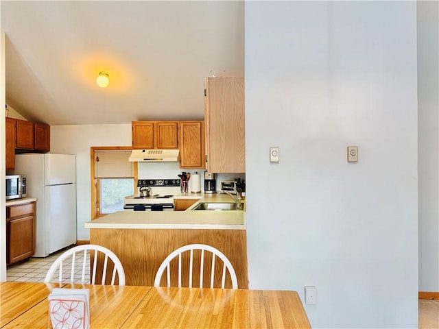 kitchen with kitchen peninsula, light tile patterned flooring, white appliances, and sink