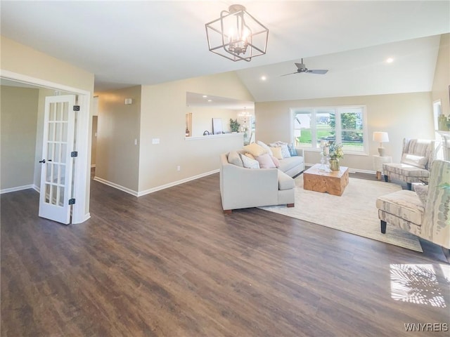 living room featuring ceiling fan with notable chandelier, dark hardwood / wood-style flooring, and lofted ceiling