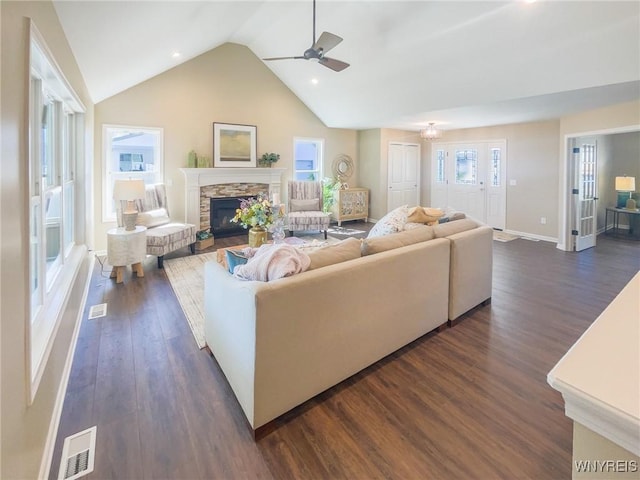 living room featuring ceiling fan, a fireplace, high vaulted ceiling, and dark wood-type flooring