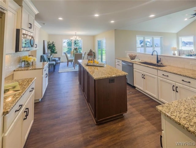 kitchen featuring appliances with stainless steel finishes, tasteful backsplash, sink, dark hardwood / wood-style floors, and a kitchen island