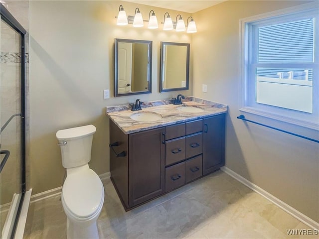 bathroom with vanity, a shower with shower door, and toilet