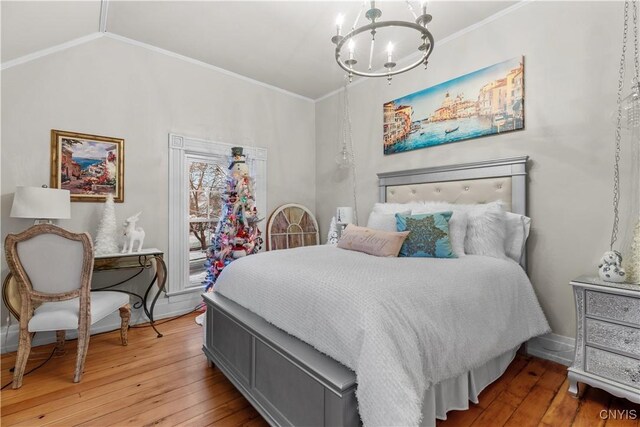 bedroom featuring a notable chandelier, lofted ceiling, ornamental molding, and light hardwood / wood-style flooring