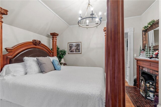 bedroom featuring crown molding, hardwood / wood-style flooring, an inviting chandelier, a fireplace, and lofted ceiling