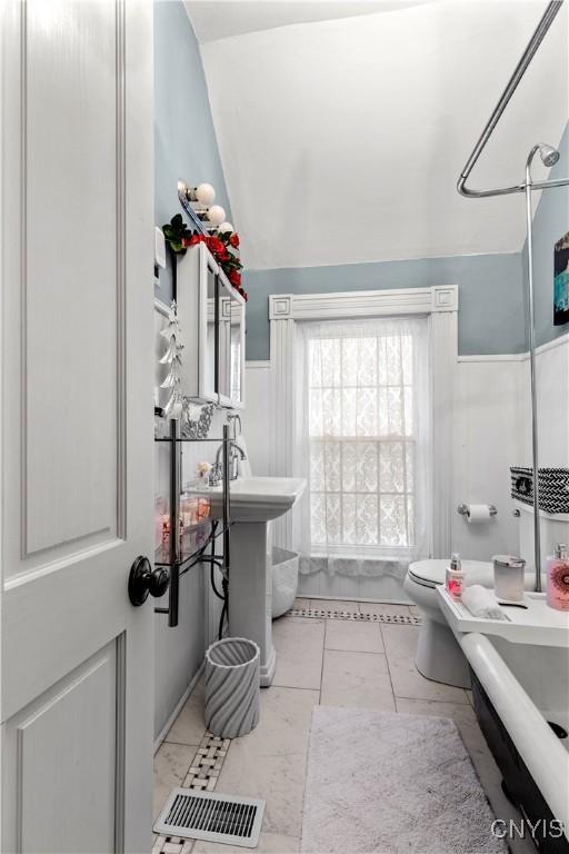 bathroom with shower / bathtub combination, lofted ceiling, and toilet